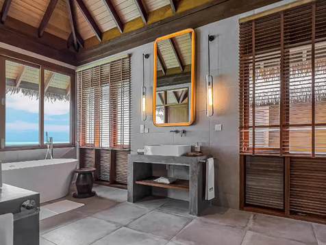 Renovated water villa bathroom with timber shutters